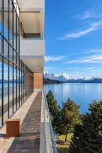 Alojamiento contemporáneo frente a un lago y montañas