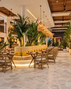 Restaurante tropical con vegetación y lámparas artesanales